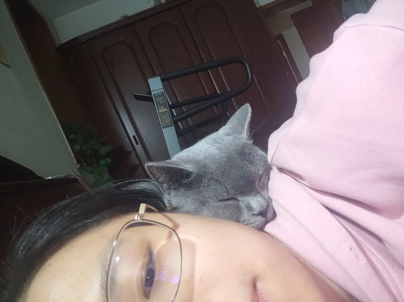 七仔闭着眼，依偎在穿粉色衣服的妈妈身旁